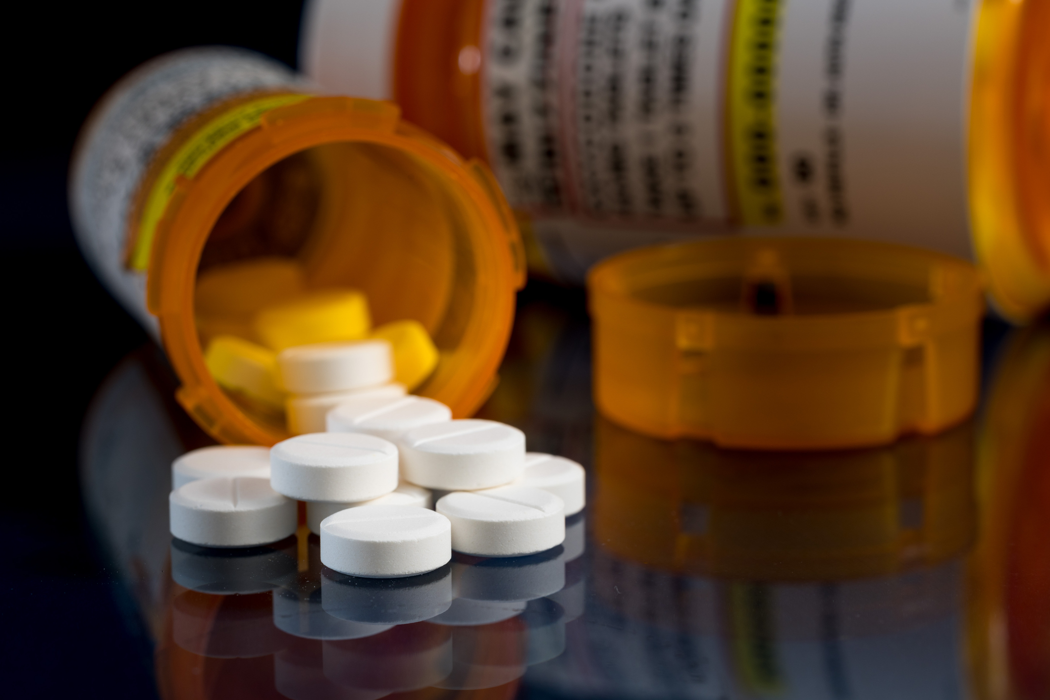 Prescription bottle for Oxycodone tablets and pills on glass table with reflections | LMCT